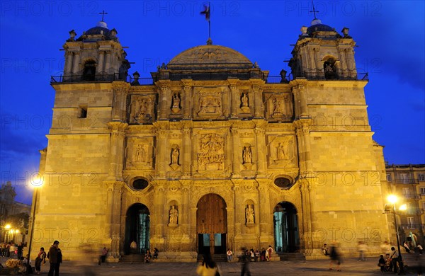 Mexico, Oaxaca, Baroque exterior facade of the Cathedral at night with people in the square in foreground. Photo : Nick Bonetti
