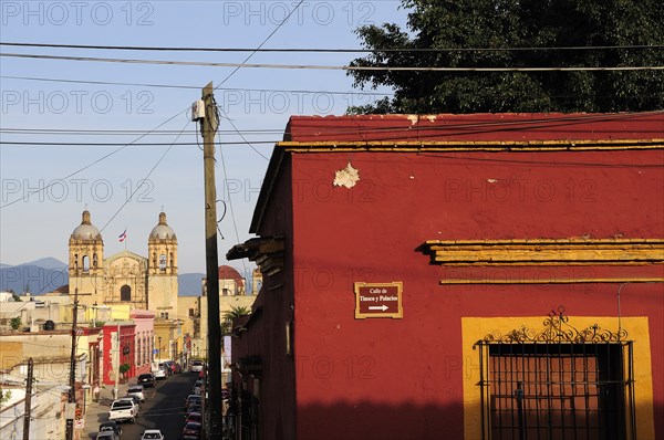 Mexico, Oaxaca, View towards church of Santo Domingo from street corner and red and ochre painted building. Photo : Nick Bonetti