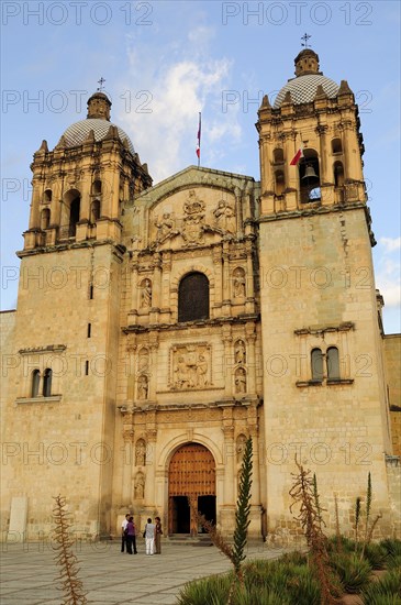 Mexico, Oaxaca, Church of Santo Domingo exterior facade and bell towers with small group of people standing outside entrance. Photo : Nick Bonetti