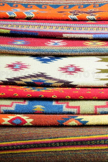 Mexico, Oaxaca, Detail of stacked weavings and carpets by Tomas and Arnulfo Mendoza. Photo : Nick Bonetti