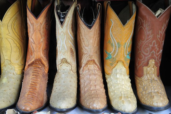 Mexico, Jalisco, Guadalajara, Line of embroidered leather boots for sale. Photo : Nick Bonetti