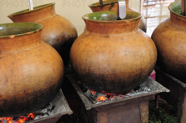 Mexico, Oaxaca, Large earthenware pots of food cooking over hot coals. Photo : Nick Bonetti