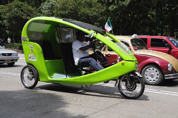 Mexico, Federal District, Mexico City, Pedi taxi and VW taxi waiting on road. Photo : Nick Bonetti