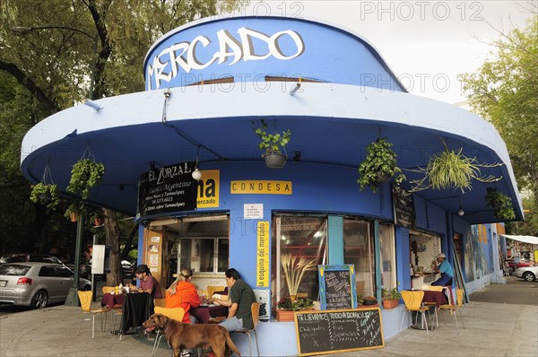 Mexico, Federal District, Mexico City, Condesa District Street restaurant blue painted exterior with customers sitting at outside tables.. Photo : Nick Bonetti