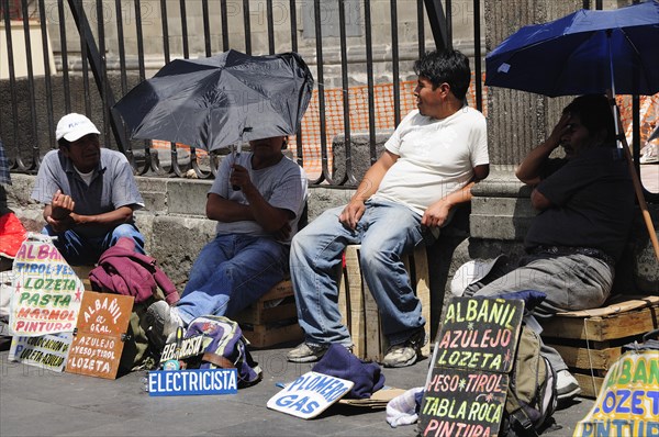 Mexico, Federal District, Mexico City, Workers plying trade outside the Cathedral in the Zocalo using umbrellas for shade. Photo : Nick Bonetti