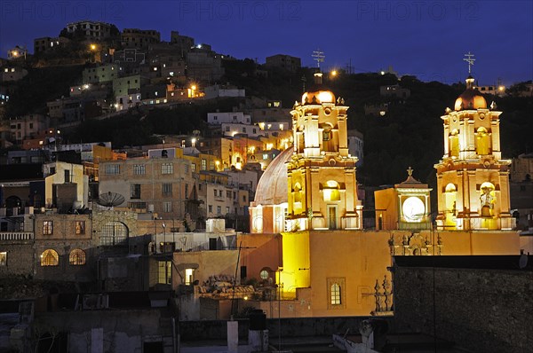 Mexico, Bajio, Guanajuato, Church of San Francisco at night with barrios on hillside beyond. Photo : Nick Bonetti