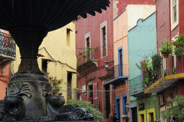 Mexico, Bajio, Guanajuato, Partly seen fountain in foreground of colourful buildings in the Plaza del Baratillo. Photo : Nick Bonetti