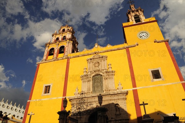 Mexico, Bajio, Guanajuato, Basilica de Nuestra Senora de Guanajuato or Basilica of Our Lady of Guanajuato. Baroque yellow painted exterior facade with clock and bell tower. Photo : Nick Bonetti