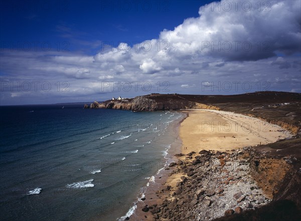 France, Bretagne, Crozon Peninsula, South west facing beach and Pointe du Toulinguet with rocky coastline and lighthouse on clifftop in distance. Photo : Bryan Pickering