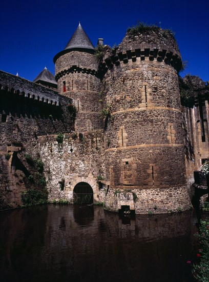 France, Bretagne, Ille-et-Vilaine, Fougeres. Defensive walls and towers of the chateau dating from 11th to 15th century rising from moat. Photo : Bryan Pickering