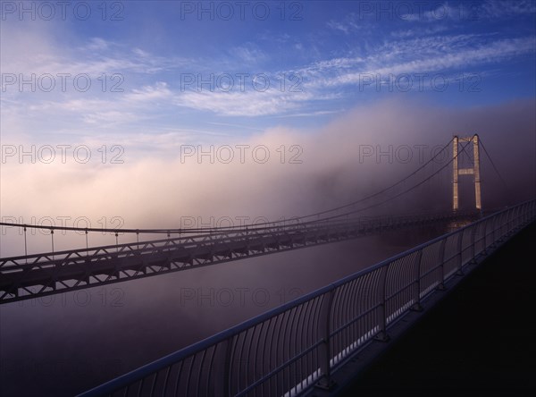 France, Bretagne, Finistere, Ile de Crozon. View of the old bridge to Crozon over the River Aulne from the new Pont de Terenez suspension bridge completed in 2011 in fog.. Photo : Bryan Pickering