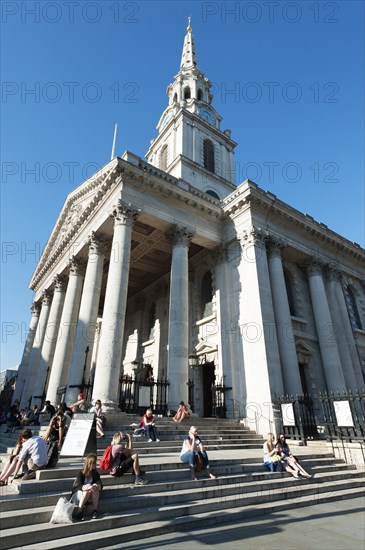 England, London, Trafalgar Square tourists sat on the steps of St Martin in the Fields Church. Photo : Paul Tomlins