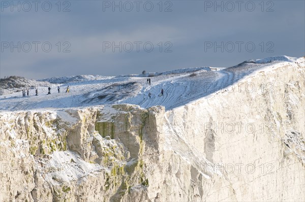 England, East Sussex, Seaford Head, Snow on cliffs with people toboganing. Photo : Bob Battersby