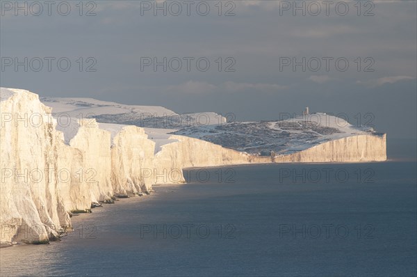 England, East Sussex, Seven Sisters, Snow covered coastline from Birling gap showing the coastguard Cottages in the foreground and Belle Tout lighthouse in the distance.. Photo : Bob Battersby