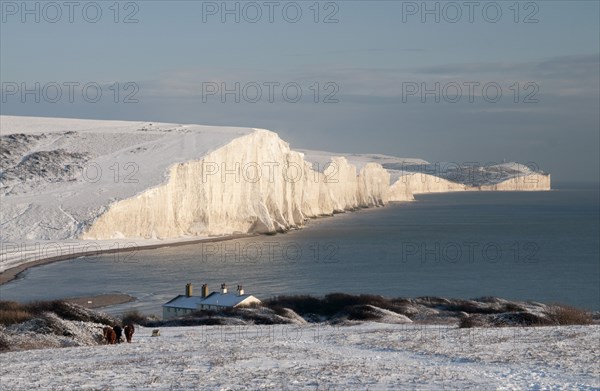 England, East Sussex, Seven Sisters, Snow covered coastline from Birling gap showing the coastguard Cottages in the foreground and Belle Tout lighthouse in the distance.. Photo : Bob Battersby
