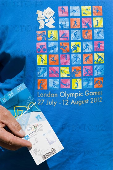 England, London, An Olympic spectator wearing an official T-shirt holding their official ticket for a Swimming session in the Aquatic Centre in the Olympic Park. Photo : Paul Seheult