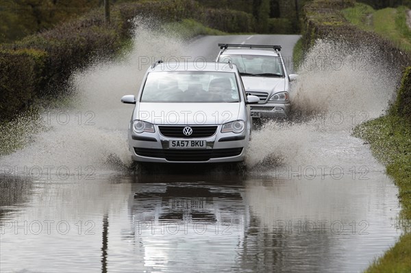 England, Kent, Flooding, Flooded country road with cars driving slowly through waters. Photo : Sean Aidan