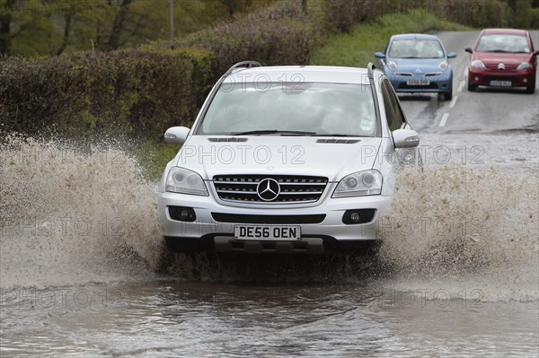 England, Kent, Flooding, Flooded country road with cars driving slowly through waters. Photo : Sean Aidan