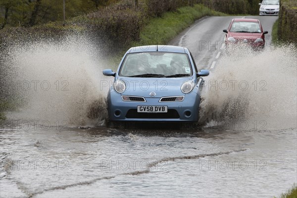 England, Kent, Flooding, Flooded country road with cars driving slowly through waters. Photo : Sean Aidan