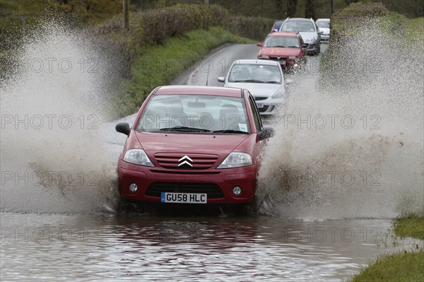 England, Kent, Flooding, Flooded country road with cars driving slowly through waters. Photo : Sean Aidan