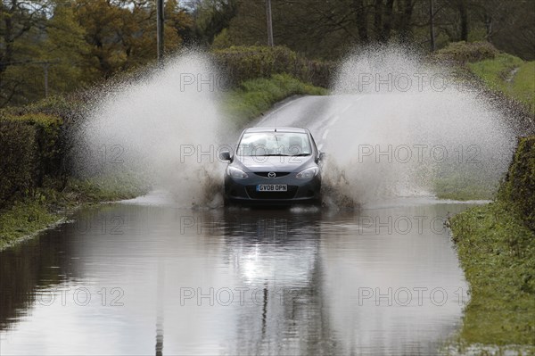 England, Kent, Flooding, Flooded country road with cars driving slowly through waters. Photo : Sean Aidan