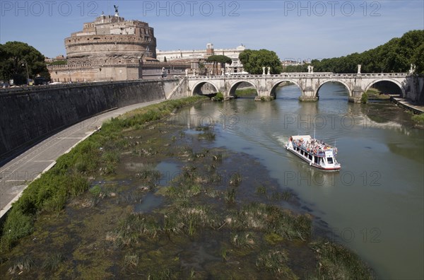 Italy, Lazio, Rome, Tourist boat on the Tiber River in front of the Bridge of Ponte Sant Angelo & Castel Sant Angelo. Photo : Bennett Dean