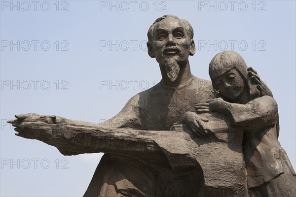 Vietnam, Ho Chi Minh City, Statue of Ho Chi Minh holding a child outside the Peoples Committee Building. Photo : Mel Longhurst