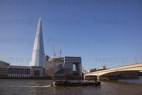 England, London, Southwark southbank Barge passing under London Bridge with the Shard skyscraper designed by Renzo Piano in the citys London Bridge Quarter. Photo : Stephen Rafferty
