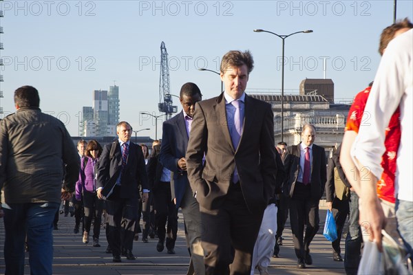 England, London, Early morning commuters crossing London Bridge towards the City Financial district. Photo : Stephen Rafferty