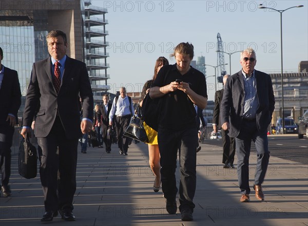 England, London, Early morning commuters crossing London Bridge towards the City Financial district. Photo : Stephen Rafferty