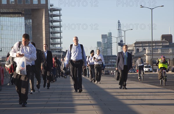England, London, Early morning commuters crossing London Bridge towards the City Financial district. Photo : Stephen Rafferty