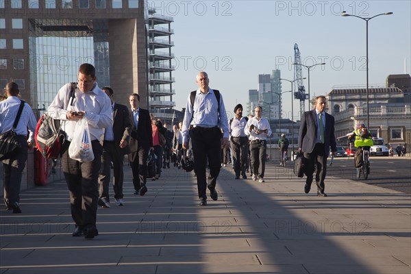 England, London, Early morning commuters crossing London Bridge towards the City Financial district. Photo : Stephen Rafferty