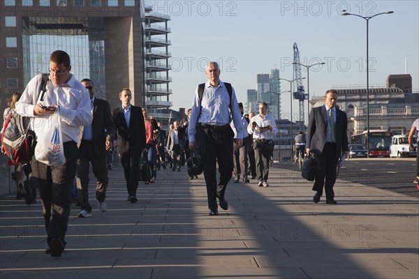 England, London, Early morning commuters crossing London Bridge towards the City Financial district. Photo : Stephen Rafferty