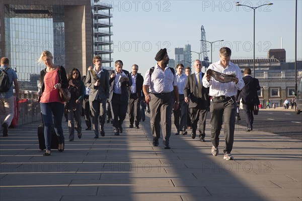 England, London, Early morning commuters crossing London Bridge towards the City Financial district. Photo : Stephen Rafferty