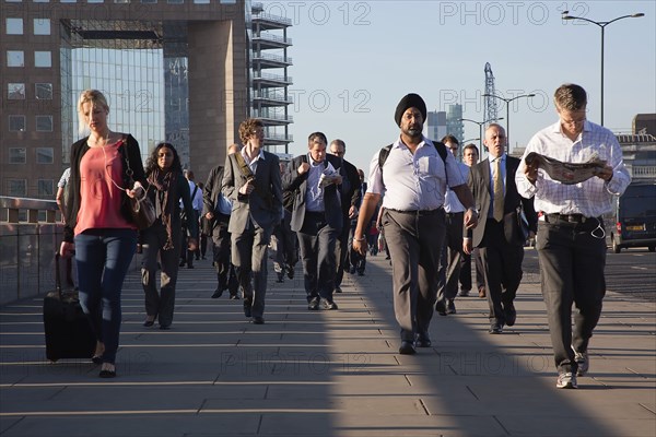 England, London, Early morning commuters crossing London Bridge towards the City Financial district. Photo : Stephen Rafferty