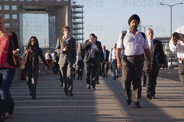 England, London, Early morning commuters crossing London Bridge towards the City Financial district. Photo : Stephen Rafferty