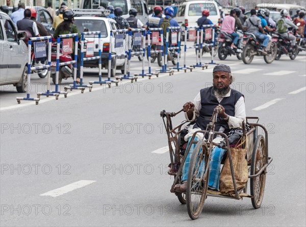 Nepal, Kathmandu, Old man using hand pedal powered tricycle. Photo : Sergey Orlov