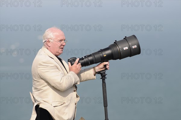 England, East Sussex, Beachy Head, Plane enthusiast photographing air display with long lens on a monopod during the Airbourne airshow. Photo : Bob Battersby