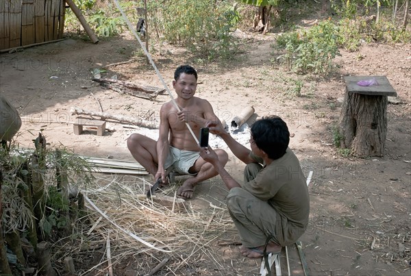 Laos, Mekong, Man in small village near the Mekong having his picture taken by man with mobile telephone. 
Photo Richard Rickard / Eye Ubiquitous