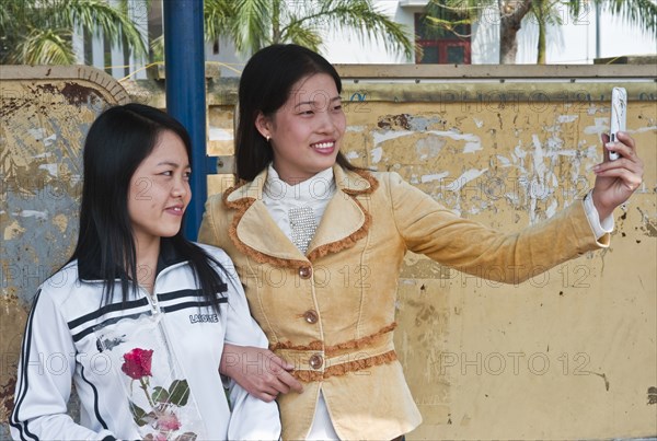Vietnam, People, Two Young Ladies taking a picture of them selves with a camera phone. 
Photo Richard Rickard / Eye Ubiquitous