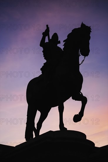 Spain, Madrid, Statue of King Philip II in Plaza Mayor silhouetted against evening sky. 
Photo Hugh Rooney / Eye Ubiquitous