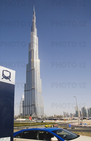 UAE, Dubai, Metro sign and taxi in front of Burj Khalifa tower. 
Photo John Dakers / Eye Ubiquitous