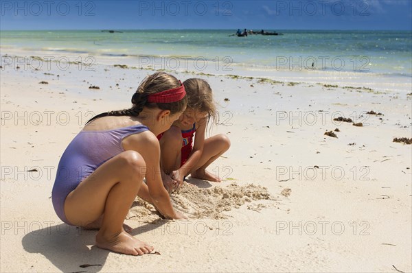 Zanzibar, Paje, Two young girls playing in the hot sunshine of the sandy beach. . 
Photo Nic I Anson / Eye Ubiquitous