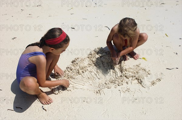 Zanzibar, Paje, Two young girls playing in the hot sunshine of the sandy beach. 
Photo Nic I Anson / Eye Ubiquitous