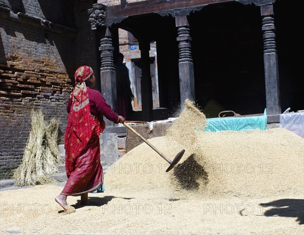 Nepal, Bhaktapur, Suryamadhi area Woman tossing grain in sun. 
Photo Nic I Anson / Eye Ubiquitous
