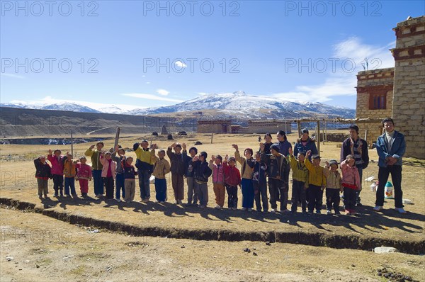 China, Szechuan Province, Tibet, School children waving outside their school. 
Photo Nic I Anson / Eye Ubiquitous