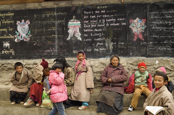 China, Szechuan Province, Tibet, Parents grandparents and children at the entrance to a private boarding school in Tibetan region. 
Photo Nic I Anson / Eye Ubiquitous