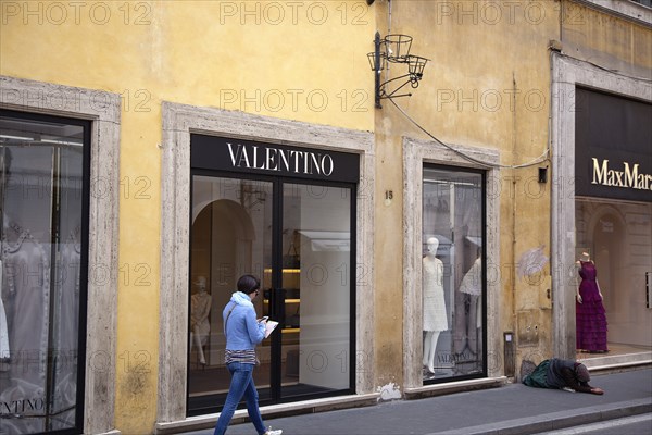 Italy, Lazio, Rome, Via del Condotti Exterior of the Valentino designer clothing shop with woman begging outside. . 
Photo Stephen Rafferty / Eye Ubiquitous