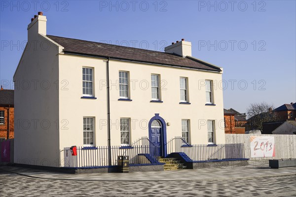 Ireland, North, Derry, Former Ebrington Barracks building with blue doorway and small Derry 2013 Year of Culture banner. 
Photo Hugh Rooney