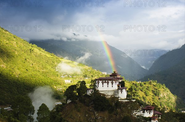 Bhutan, Lhuentse Dzong, Lhuentse Dzong with colourful rainbow overhead. 
Photo Nic I'Anson